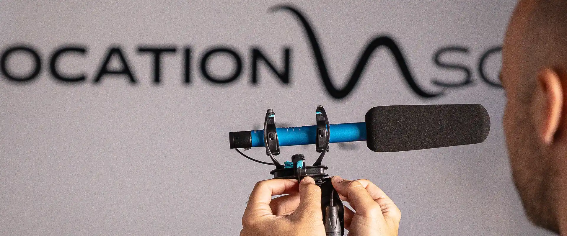 A display of various professional microphone suspensions and shotgun mic shock mounts, including Rycote Lyre models on pistol grips, ready for location sound recording and rental in Italy